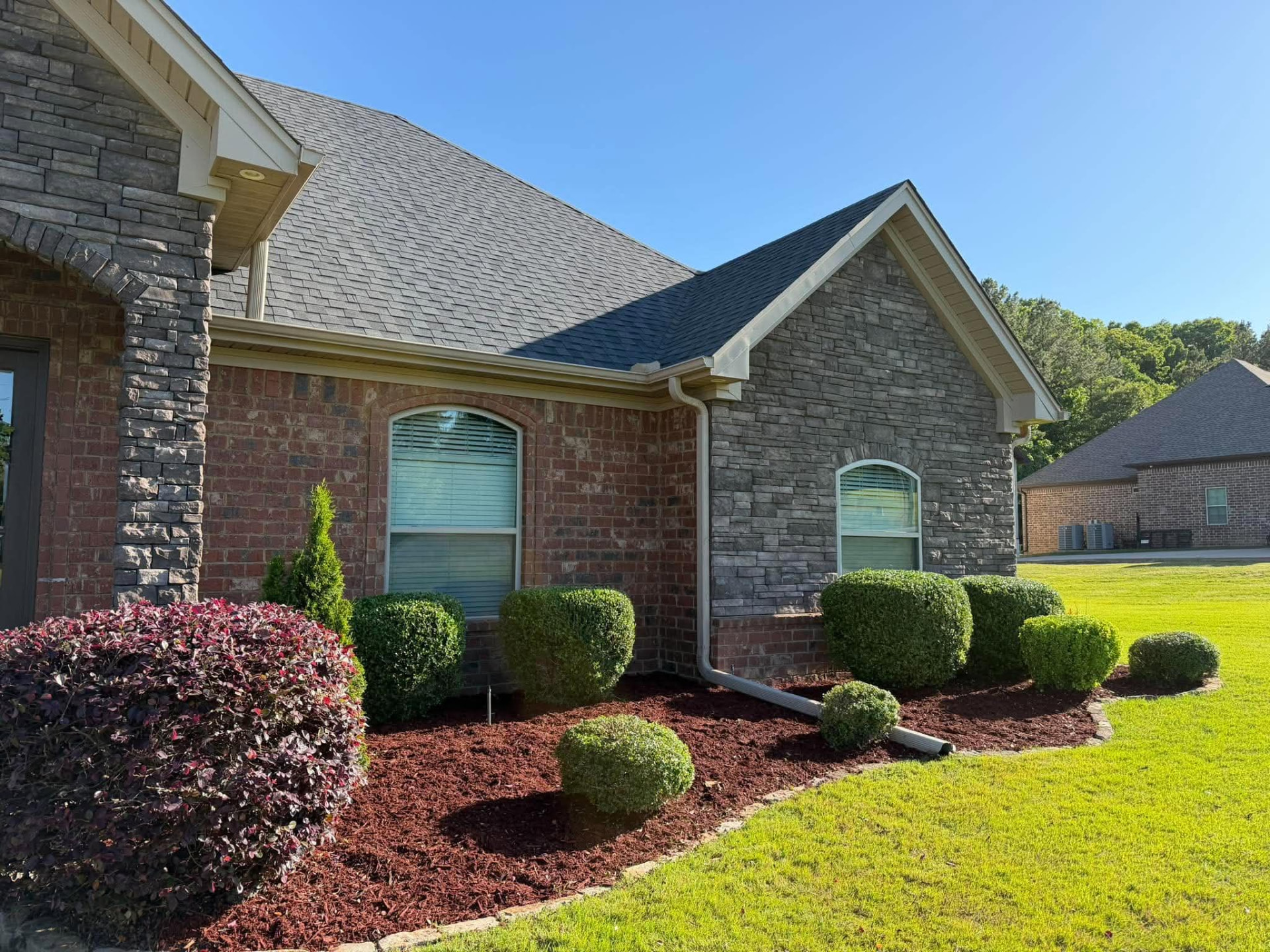 Freshly mulched planting beds with professionally shaped shrubs
